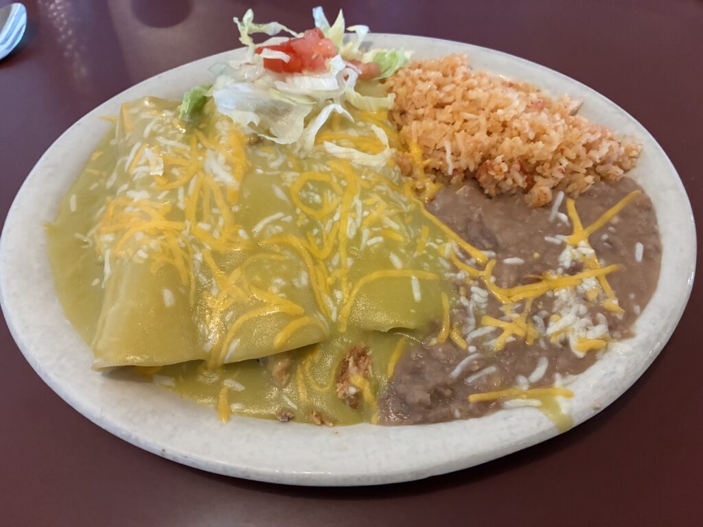 A plate of enchiladas, beans, and rice